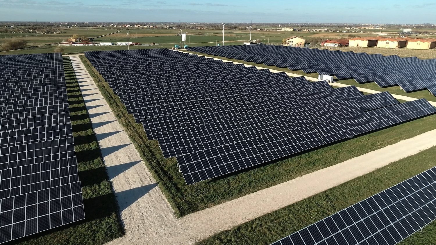 Impianto fotovoltaico e pale eoliche al tramonto